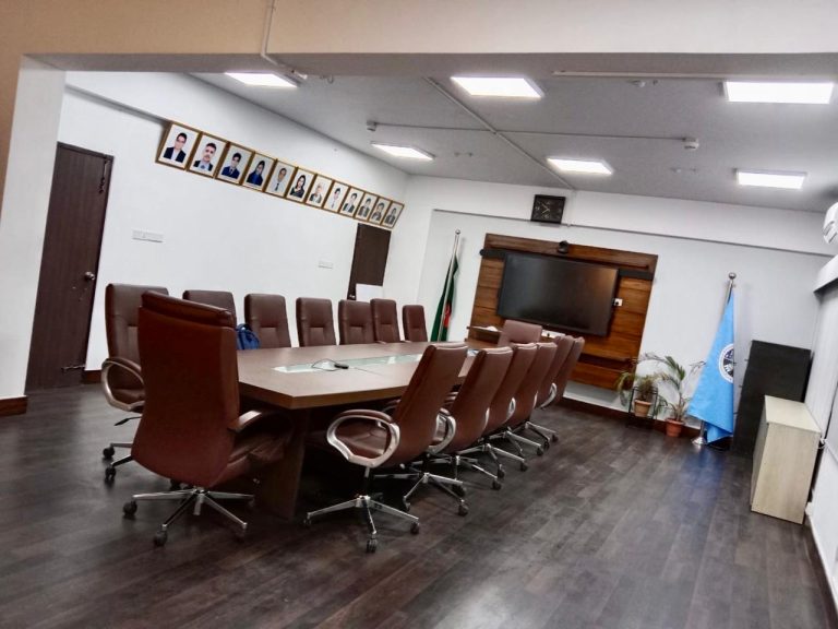 Interior view of the renovated SPARRSO conference room showing the meeting table, leather chairs, and staff portrait frames, Agargaon, Dhaka