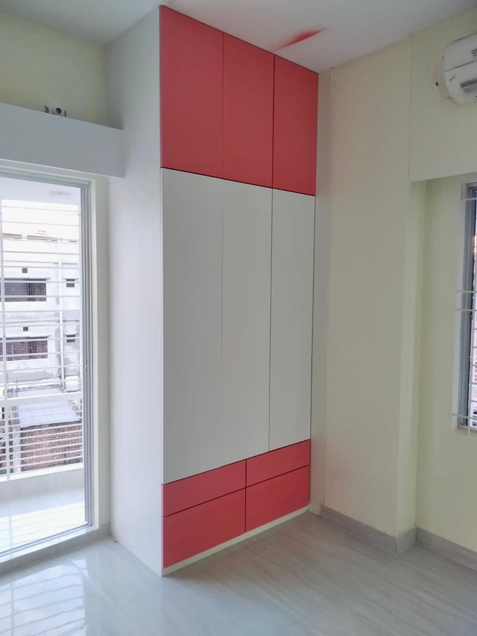 Red overhead storage cabinet being installed above a window during construction - residence interior design in Mirpur, Dhaka