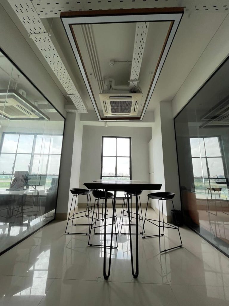 Small discussion table with high stools, coffered ceiling and mirrored partitions — minimalist office design