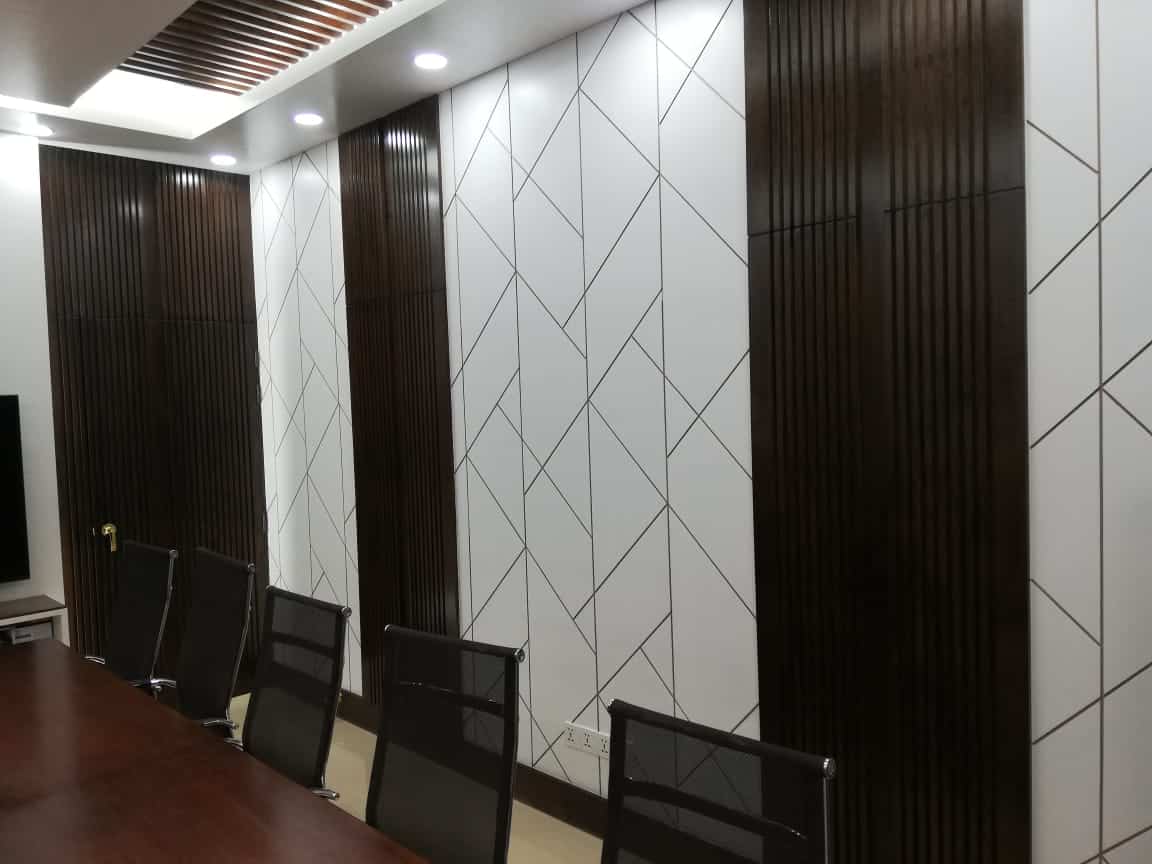 Geometric white panel wall with dark wood vertical slats, mahogany conference table and black mesh chairs in ADB Wing conference room, Planning Ministry, Dhaka