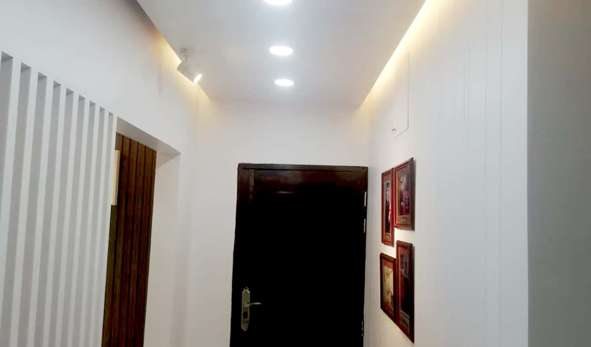 Clinic corridor with louvre partition and dark wood door leading to the doctor's private zone