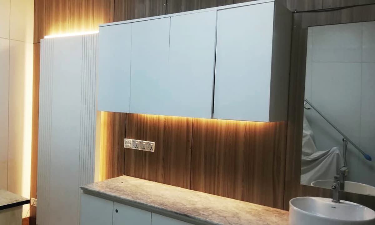 Clinic cabinetry with white overhead units and a wash basin under cove lighting