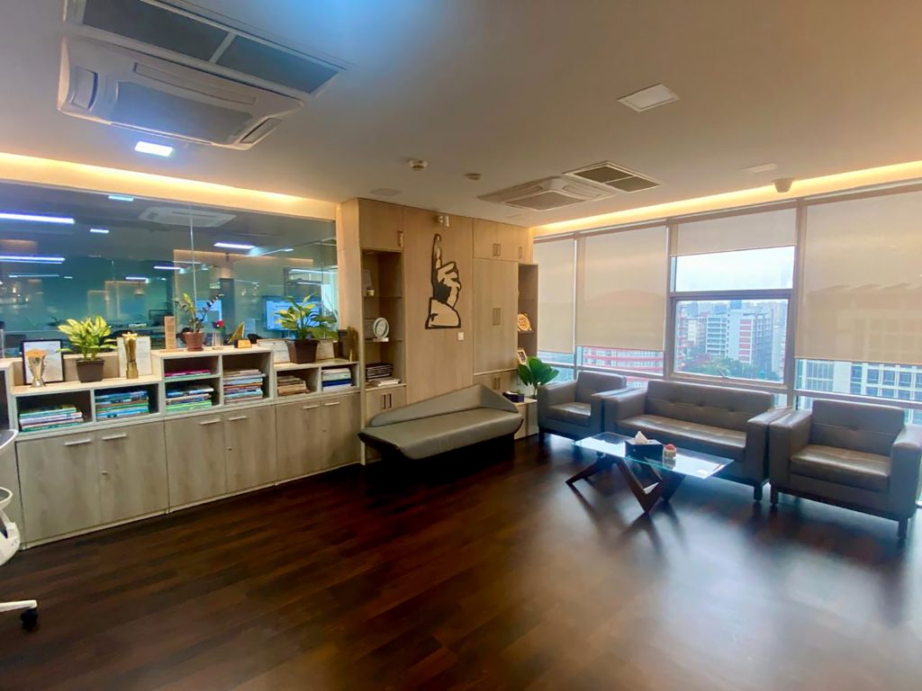 Waiting corner with sofa, coffee table, and city view beside a display counter at ICT Tower, Dhaka