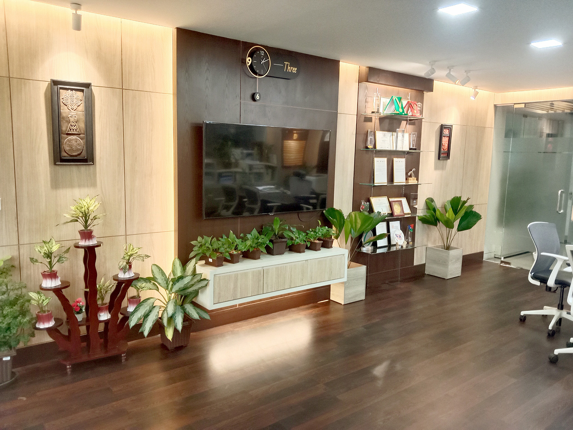 TV wall with wood panel and glass display rack for awards in the director office, Dhaka