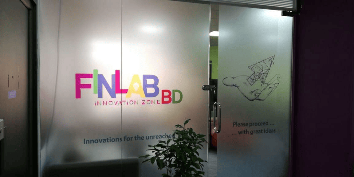 Glass entry with UNCDF FinLab branding in a modern office interior design in Bangladesh.
