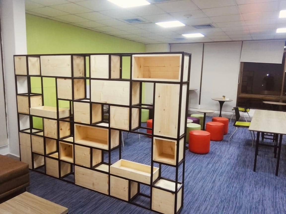 Open shelf partition dividing zones in small office design