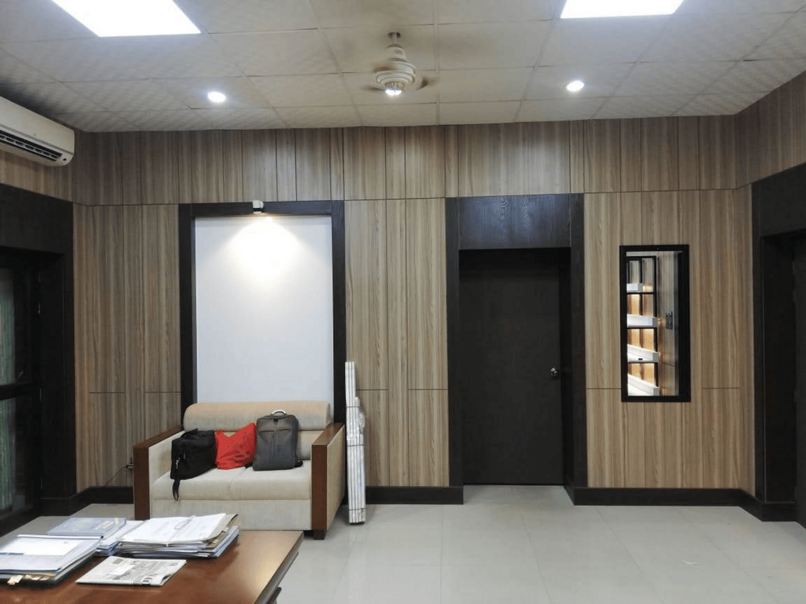Wood panel wall seating area with sofa, AC unit and mirror in Wing Chief executive office interior, Planning Commission, Dhaka