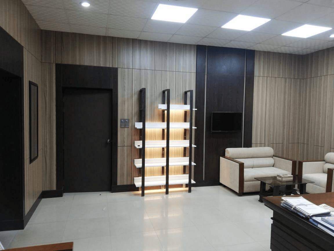 Illuminated display shelving unit and wall-mounted TV in Wing Chief executive office interior, Planning Commission, Dhaka
