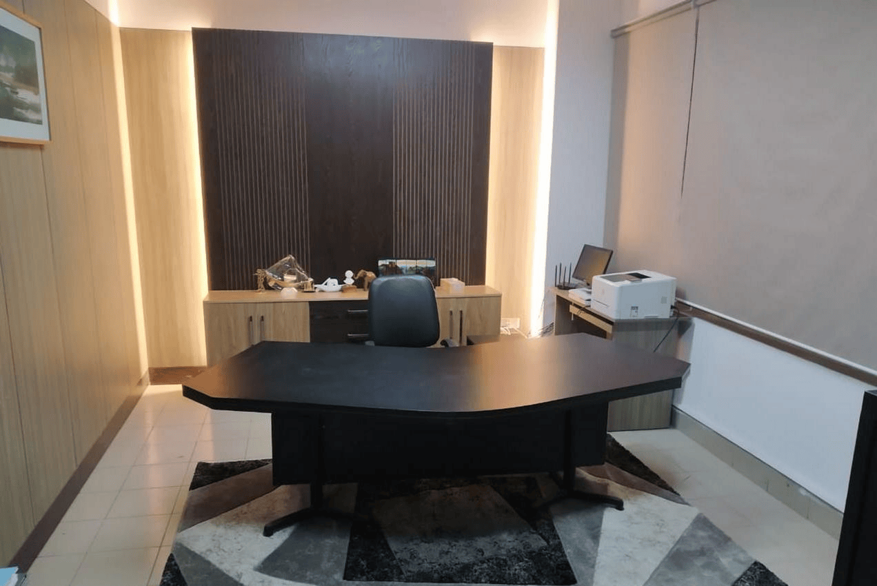 Executive office room with dark wood desk and slatted feature wall, A2i Paribahan Pool office interior design in Segunbagicha, Dhaka