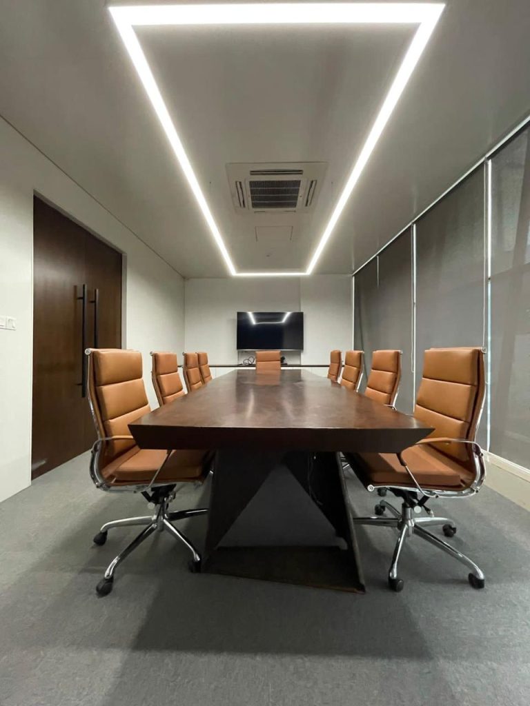 Corporate meeting room with linear ceiling lights and executive chairs