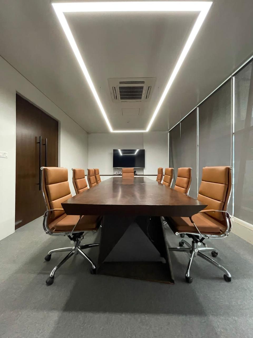 Corporate meeting room with linear ceiling lights and executive chairs