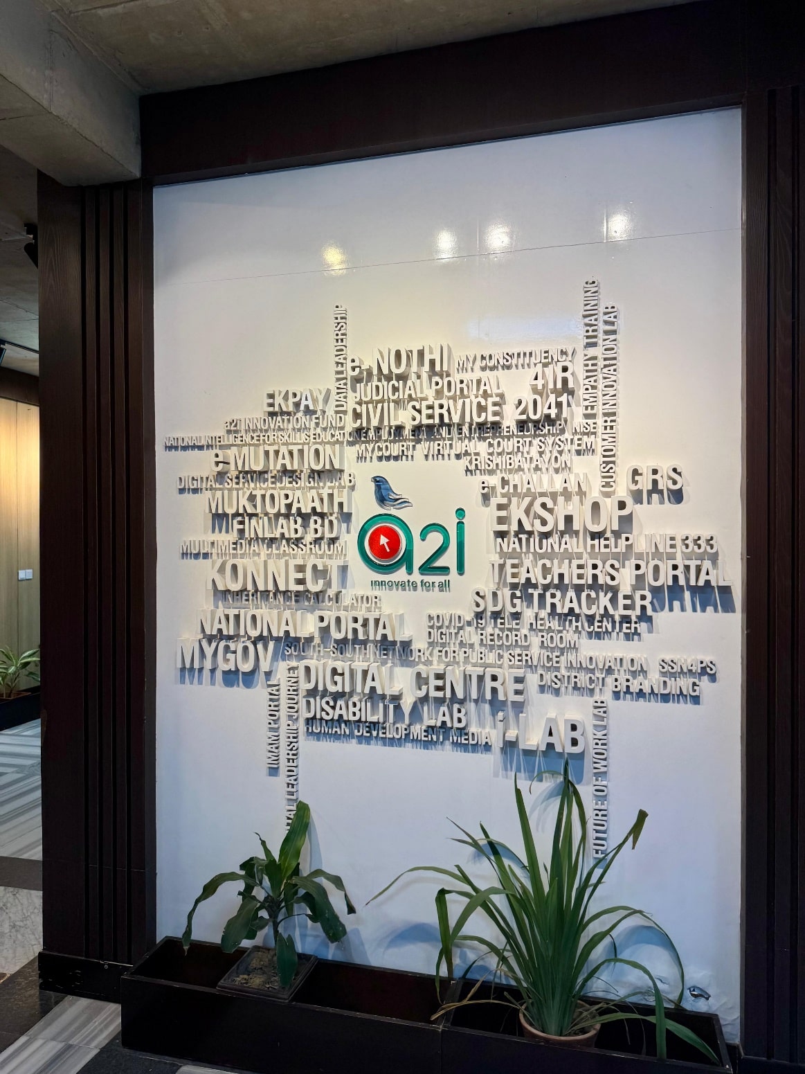 Feature wall with typography in A2i office renovation at ICT Tower, Dhaka, showcasing branding and modern interior design.