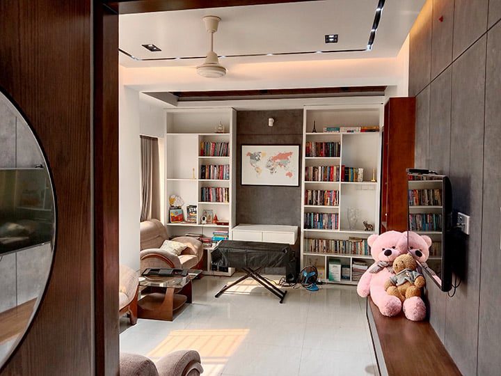 Reading corner with built-in bookshelves, world map artwork and cozy seating - residence interior design in Rampura, Dhaka