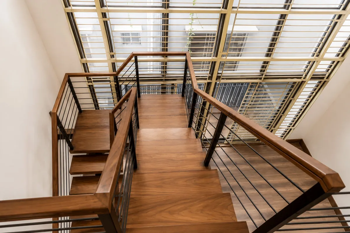 Duplex house design in Bangladesh: upper landing and stair railing under a glazed roof in a 3,600 sft Bashundhara duplex by Studio Archifiction